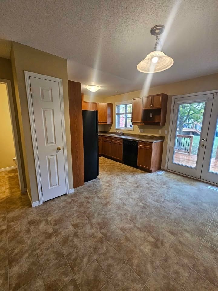 A kitchen with a white door and a black counter.