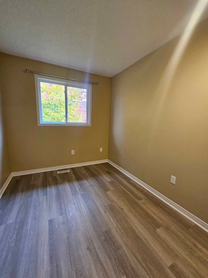 A room with a window and wooden flooring.