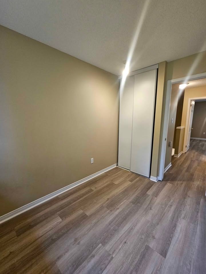 A room with a wooden floor and a white door.
