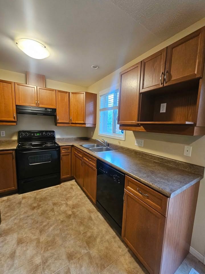 A kitchen with wooden cabinets and black appliances.