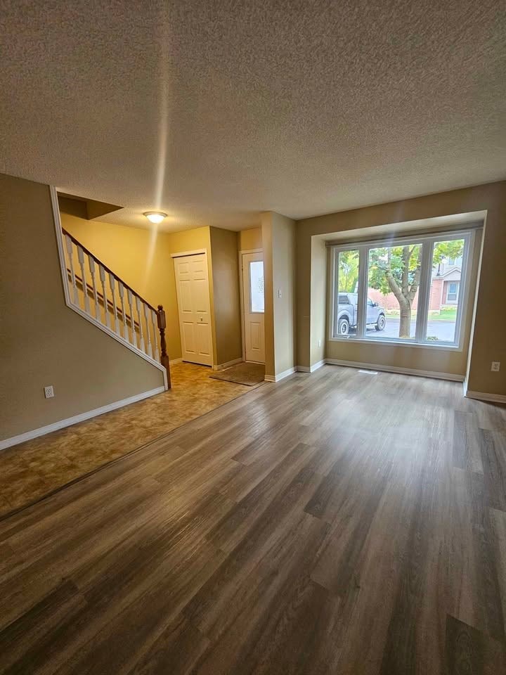 A room with wooden flooring and a staircase.