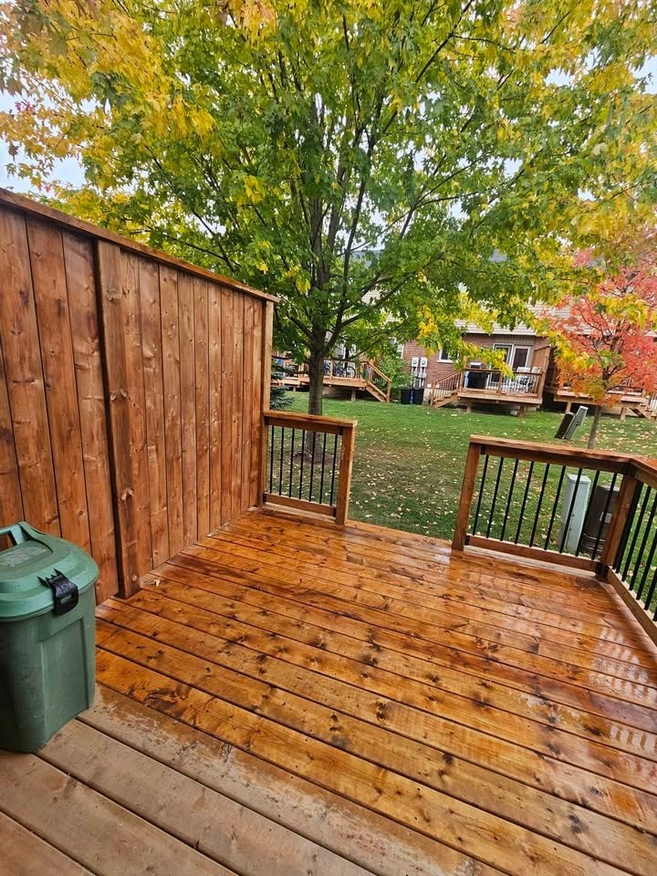 A wooden deck with a green container on it.
