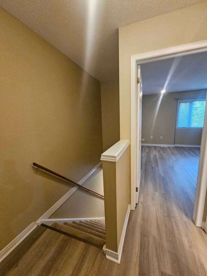A hallway with a wooden floor and a white door.