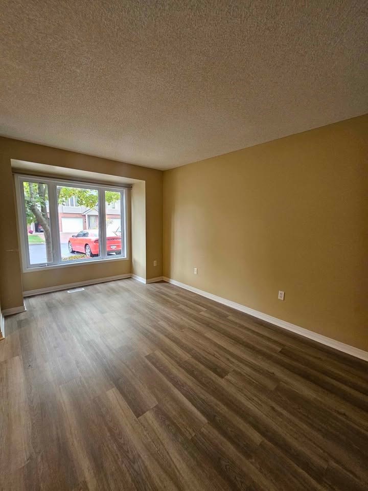 A room with a window and a wooden floor.