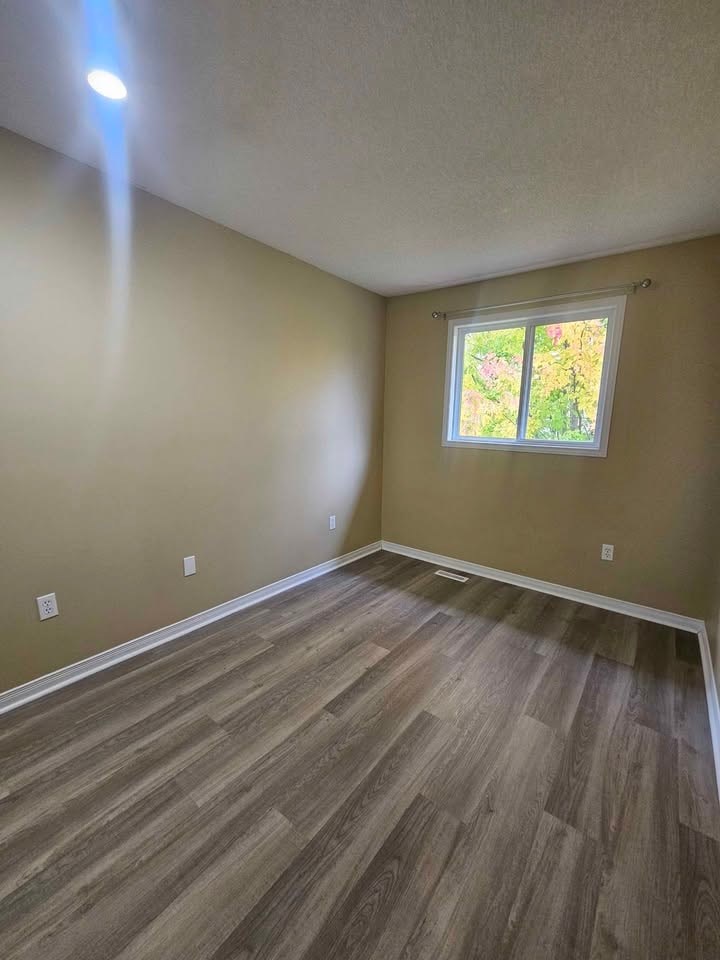 A room with a window and wooden flooring.