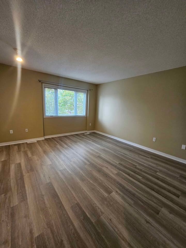 A room with wooden flooring and a window.