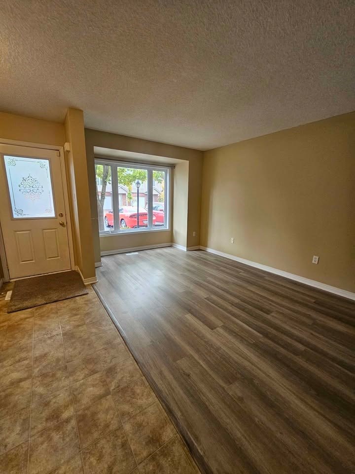 A room with wooden floors and a door leading to a balcony.