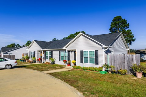A house with a grey roof and a white car parked in front.