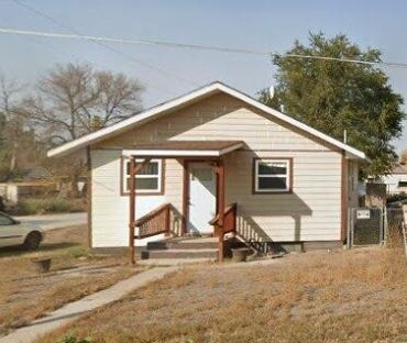 A small house with a brown door and a brown porch.