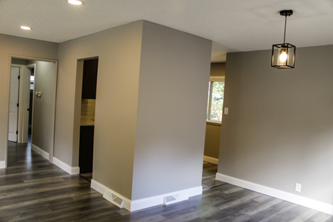 A room with a wooden floor and a hanging light fixture.