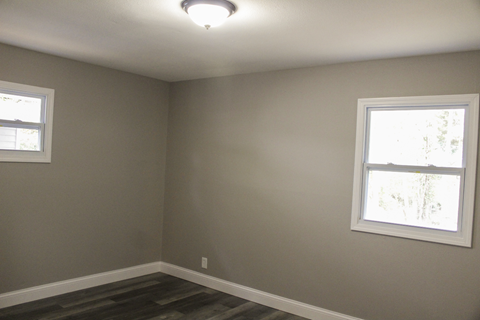 A room with a window on the left and a window on the right.