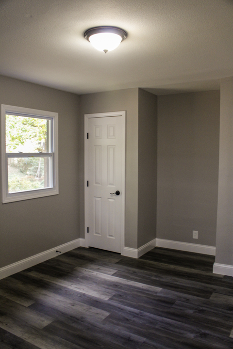 A room with a white door and a window.