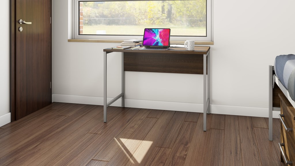 A laptop is placed on a desk with a mug beside it.