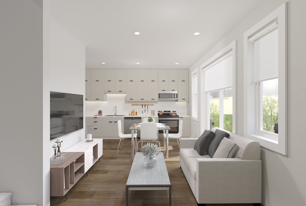 A modern living room with a grey couch and a wooden floor.
