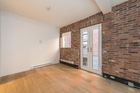 A room with a brick wall and a sliding glass door.