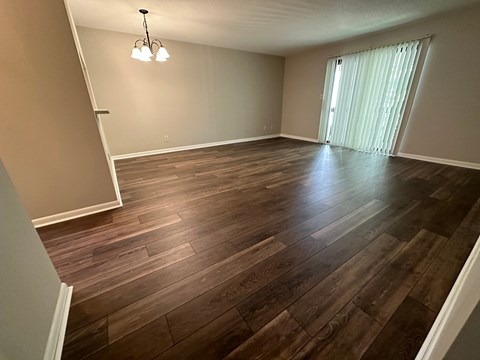 A room with wooden flooring and a chandelier.