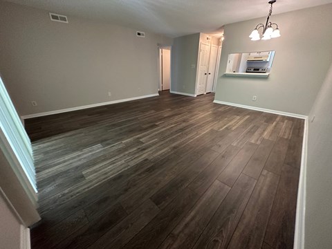 A room with wooden flooring and a chandelier.