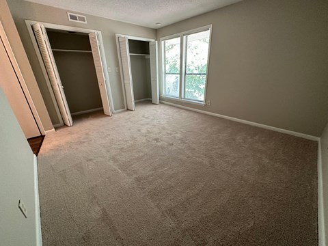 A room with carpeted floor and a window.