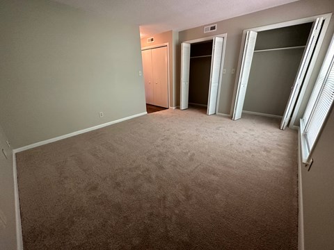 A room with carpeted floor and a white wall.