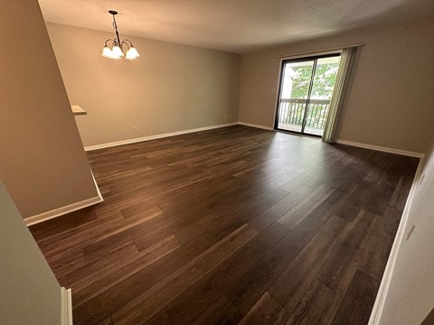 A room with wooden flooring and a chandelier.