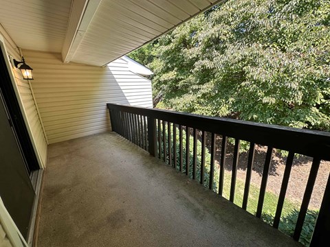 A balcony with a black railing and a light on.