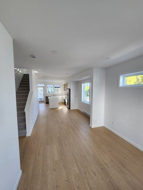 A long hallway with wooden floors and white walls.