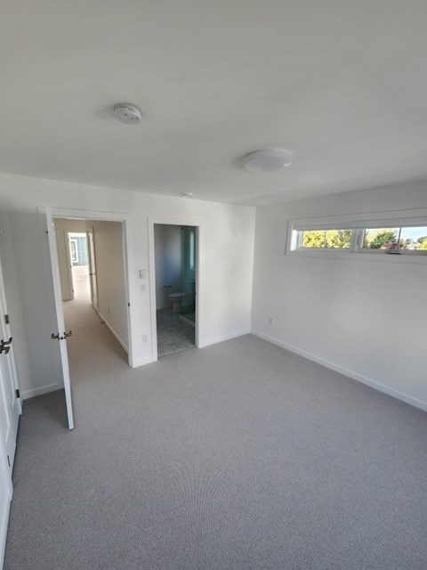 A room with a carpeted floor and a window.
