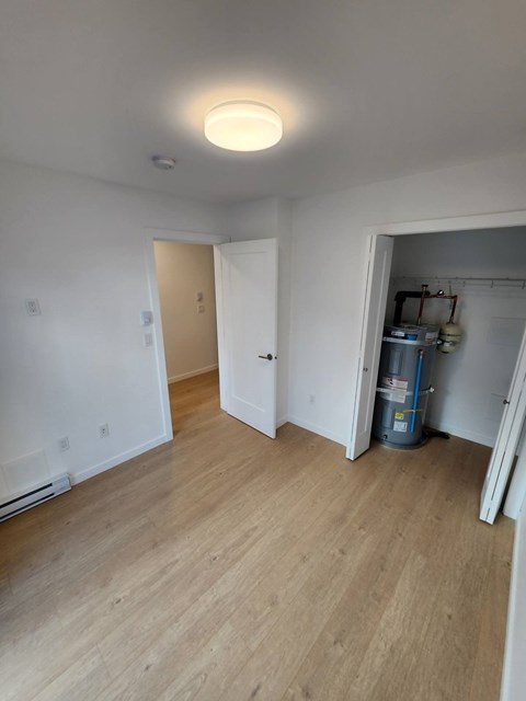 A room with a wooden floor and a white ceiling with a light fixture.