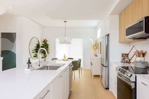 A modern kitchen with white cabinets and stainless steel appliances.