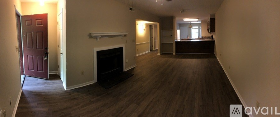 A large, empty room with a fireplace and a door on the left.