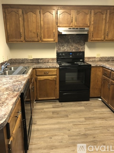 A kitchen with wooden cabinets and a black oven.