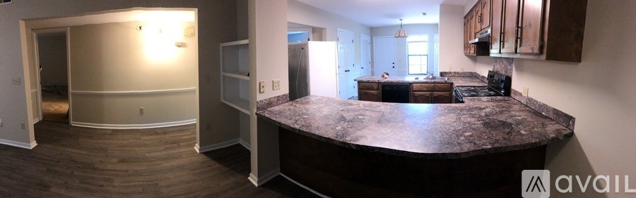 A kitchen with a granite countertop and a refrigerator.