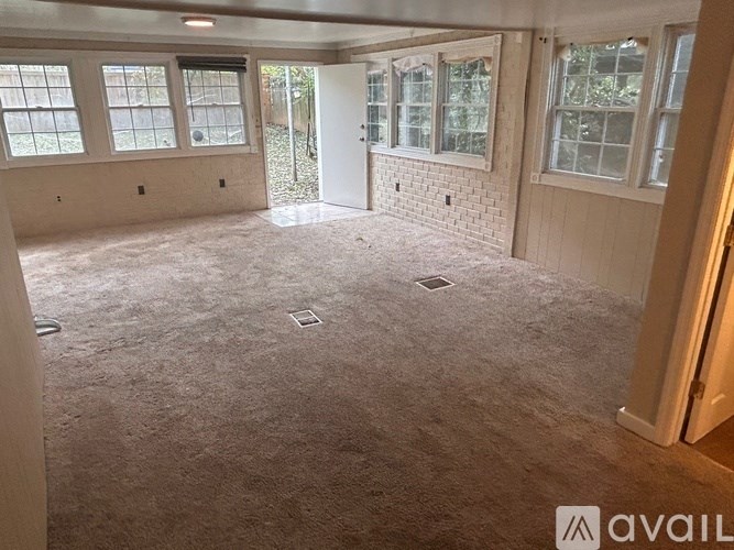 A room with a carpeted floor and a door leading to another room.