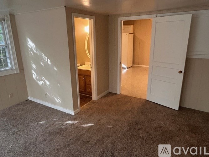 A room with a carpeted floor and a white door.