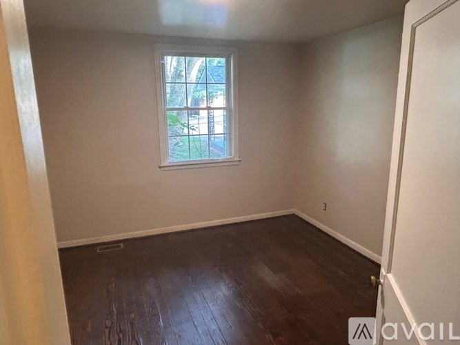 A room with a window and wooden flooring is available for rent.