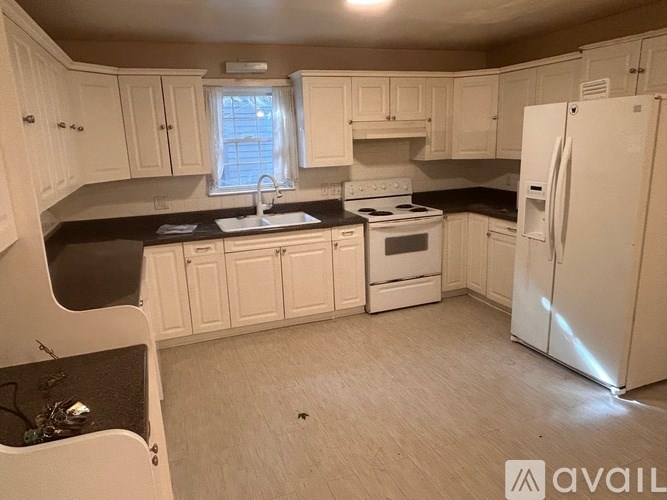A kitchen with white cabinets and appliances.