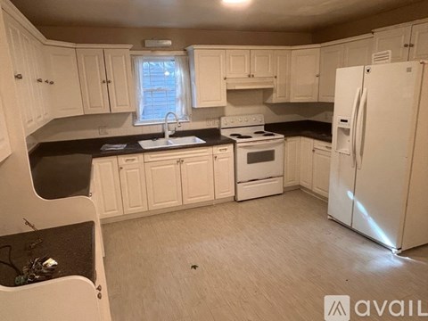 A kitchen with white cabinets and appliances.