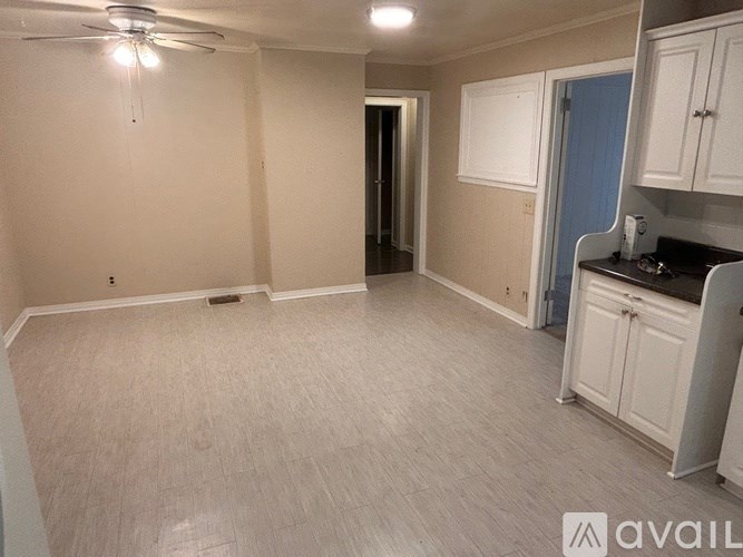A room with a fan, cabinets, and a countertop.