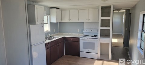 A kitchen with white appliances and brown cabinets.