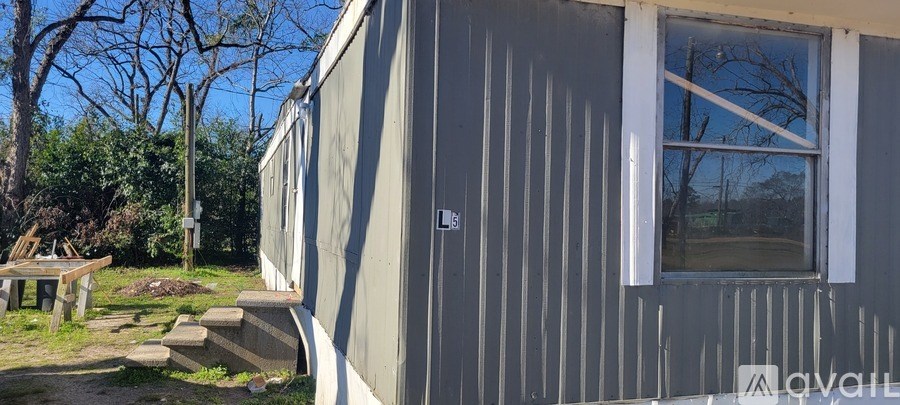 A grey house with a window and a door.