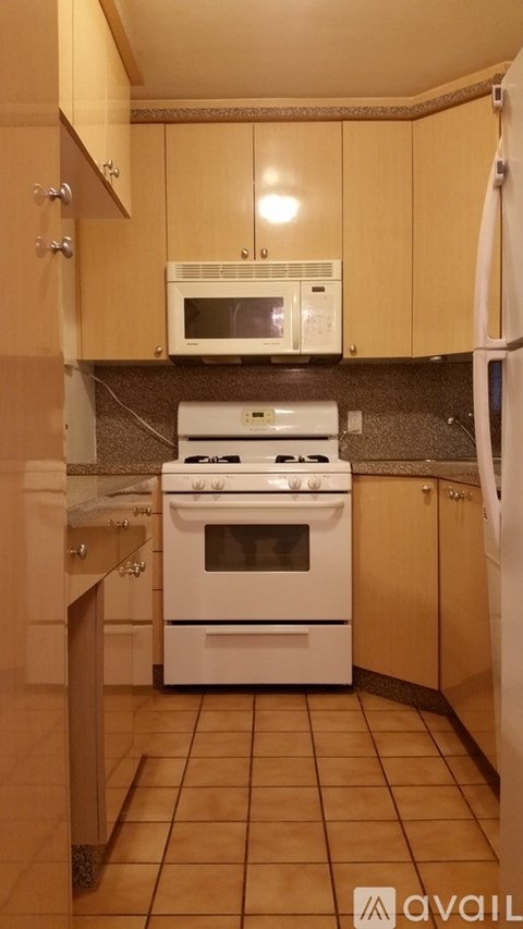 A kitchen with a white stove and microwave above it.