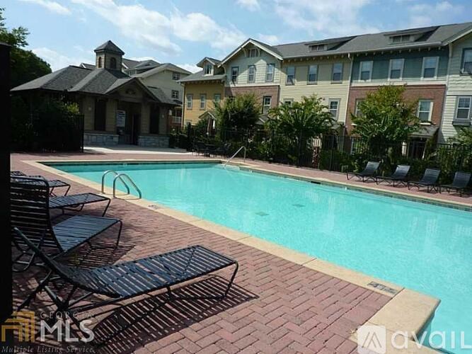A pool surrounded by chairs and buildings.