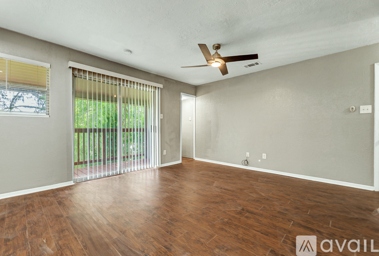 A room with wooden floors and a ceiling fan.