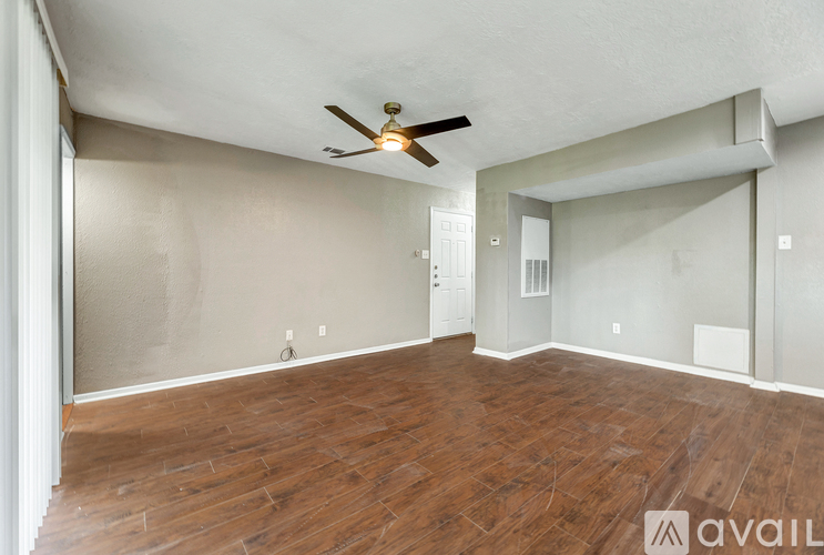 A room with wooden flooring and a ceiling fan.