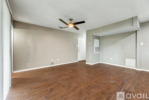 A room with wooden flooring and a ceiling fan.
