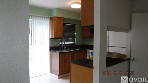 A kitchen with wooden cabinets and a black countertop.