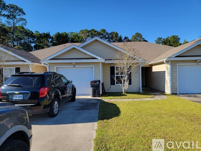 A black SUV is parked in front of a house with a driveway.
