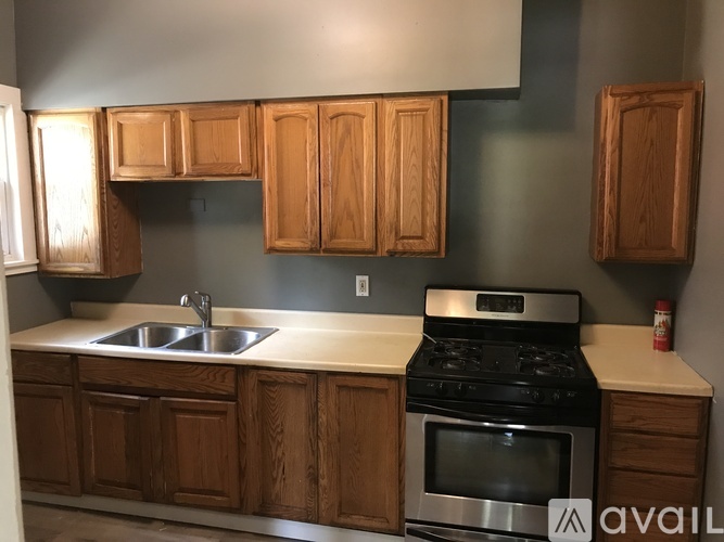A kitchen with wooden cabinets and a stove top oven.