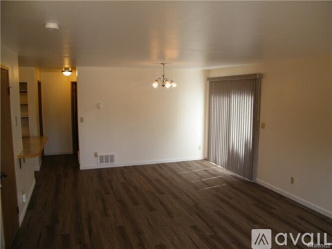 A room with wooden floors and a chandelier.