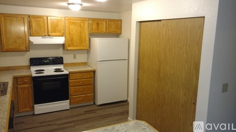 A kitchen with wooden cabinets and a white fridge.